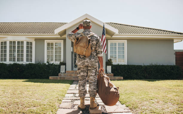 Man in military uniform arriving home with bags