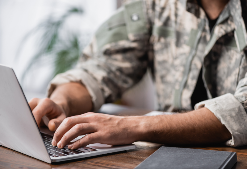 Man in military uniform using a laptop